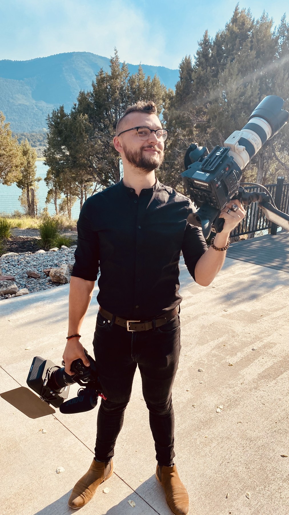 Lachlan Quintana holding two cameras on location